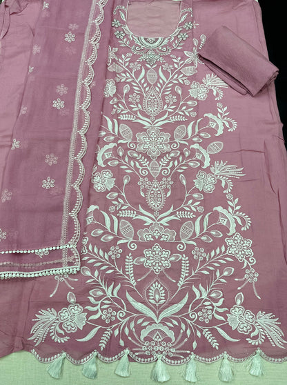 Pink fabric with intricate white embroidery and tassels 